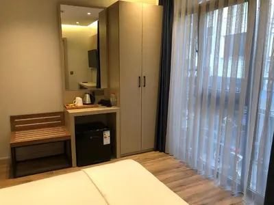 a bedroom with a large window and a mirror at The Palm Bosphorus Hotel in Istanbul