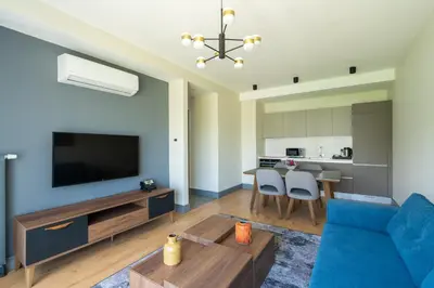 a living room with a blue couch and a tv at The Superior Living Kağıthane in Istanbul