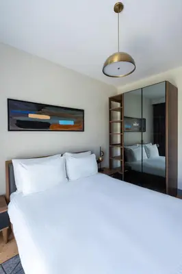 a bedroom with a large white bed and a mirror at The Superior Living Kağıthane in Istanbul