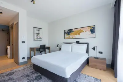 a bedroom with a large white bed and a desk at The Superior Living Kağıthane in Istanbul