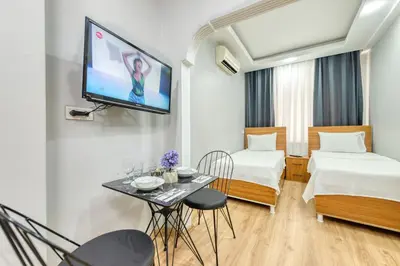 a room with two beds and a tv on the wall at Pio Apart Hotel in Istanbul
