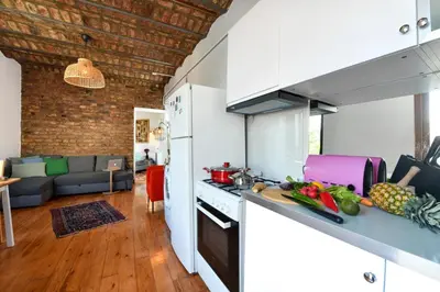 a kitchen with white appliances and a living room at Taksim-Galata Tower Is Almost In Your Bedroom And In The Balconies Rooftop Terrace with Golden Horn View in Istanbul