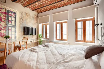 a bedroom with a large white bed and a table at Armel Homes Beyoğlu in Istanbul
