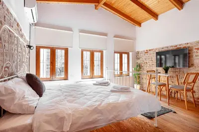 a white bedroom with a large bed and a table at Armel Homes Beyoğlu in Istanbul