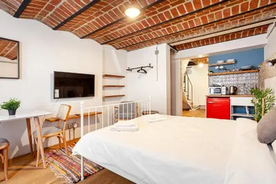 a bedroom with a white bed and a kitchen at Armel Homes Beyoğlu in Istanbul