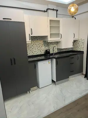a kitchen with white cabinets and a white refrigerator at Fabesco Suite in Istanbul