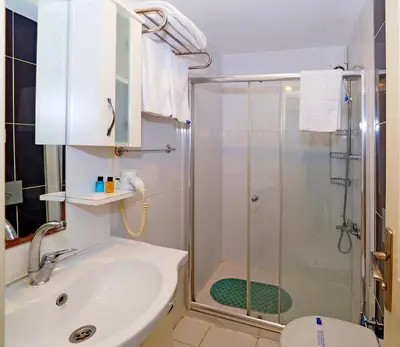 a bathroom with a shower and a sink and a toilet at Nagehan Hotel Old City in Istanbul