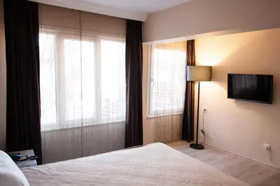 a bedroom with a bed and a television on a wall at Sun Suites in Istanbul