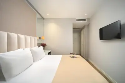 a bedroom with a white bed and a flat screen tv at Ess Hotel in Istanbul