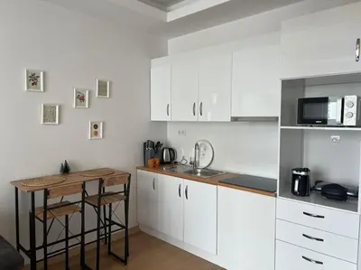 a kitchen with white cabinets and a table in it at Cozy Homes 2 Room Apartment Well Designed in Esenyurt