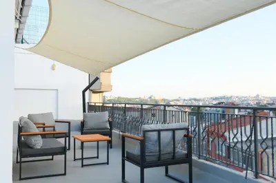 a balcony with chairs and tables on top of a building at Urban Quarters - Boğazkesen in Istanbul