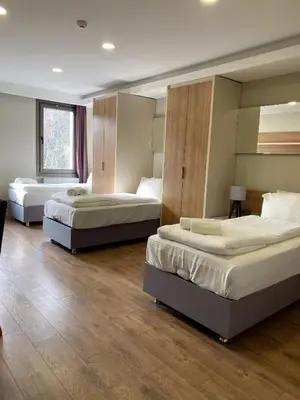 three beds in a room with wooden floors at Frezya Family Hotel in Istanbul