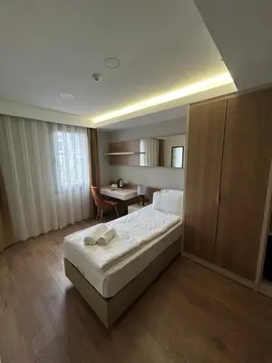 a bedroom with a bed and a desk in it at Frezya Family Hotel in Istanbul