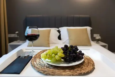 a plate of grapes and a glass of wine on a bed at The best of the Bosphorus & comfortable apartment in Istanbul