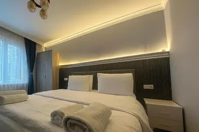 a bedroom with a large bed with white sheets and pillows at Ozer Hotel & Apartments in Istanbul