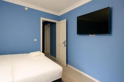 a bedroom with a bed and a flat screen tv at Ozer Hotel & Apartments in Istanbul