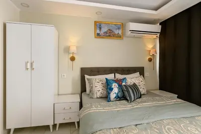 a bedroom with a bed with a white cabinet and pillows at Ozer Hotel & Apartments in Istanbul