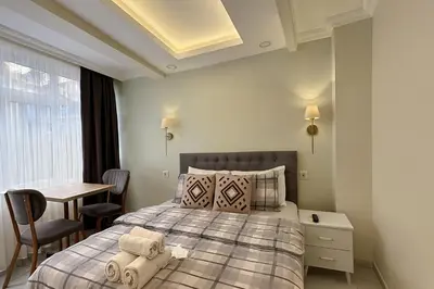 a bedroom with a bed and a table and a window at Ozer Hotel & Apartments in Istanbul