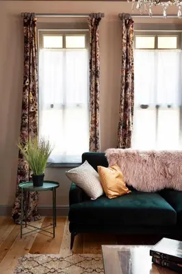 a living room with a green couch and two windows at Tastefully decorated house in Old city - Rose in Istanbul