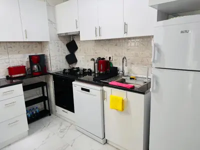a kitchen with white cabinets and a white refrigerator at Jasmin in Istanbul