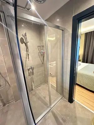 a shower with a glass door in a bedroom at Sea Sparkle in Istanbul