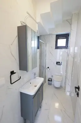 a white bathroom with a sink and a toilet at Orkide Sapanca in Sapanca