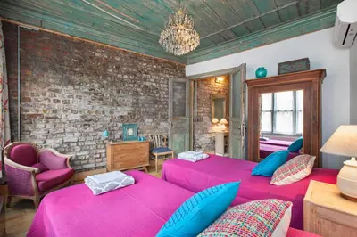 a bedroom with two beds and a brick wall at Turquoise House Featured in Elle Decor Magazine in Istanbul