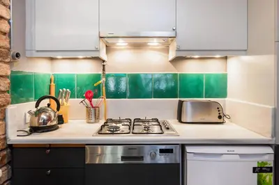 a kitchen with white and green tiles on the wall at Turquoise House Featured in Elle Decor Magazine in Istanbul