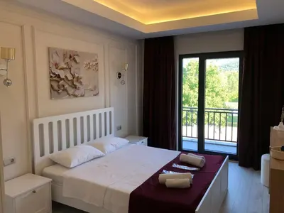a bedroom with a large bed and a balcony at GateMaşukiye in Kartepe