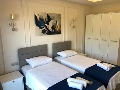 a room with two beds and a painting on the wall at GateMaşukiye in Kartepe