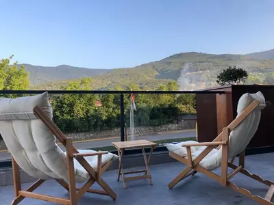 two chairs and a table on a balcony with a view at GateMaşukiye in Kartepe