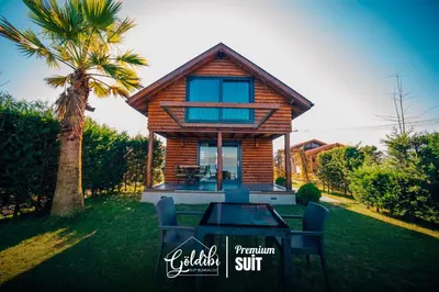 a house with a table and chairs in the yard at Sapanca Göldibi Suit Bungalov in Sakarya