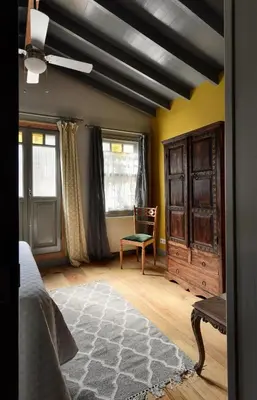 a bedroom with a bed and a chair and windows at Golden Horn Views from The Saffron House in Old Istanbul in Istanbul