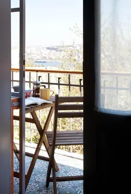 a table and chair on a balcony with a view at Enjoy Golden Horn views from Tangerine house in Istanbul