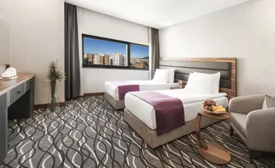 a hotel room with two beds and a couch at Lilium Hotel & Suites in Bursa