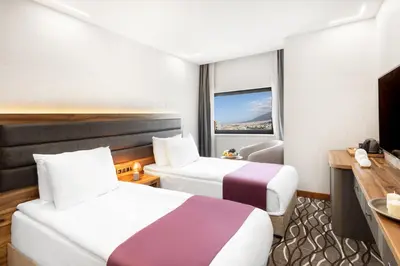 a hotel room with two beds and a window at Lilium Hotel & Suites in Bursa