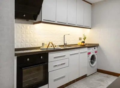 a kitchen with a sink and a washing machine at Lilium Hotel & Suites in Bursa