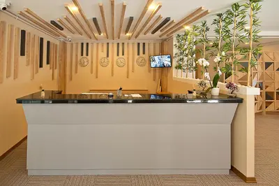 a lobby with a large counter with flowers on the wall at Lion City Hotel in Buyukcekmece