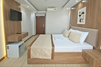 a small bedroom with a bed and a tv at Lion City Hotel in Buyukcekmece