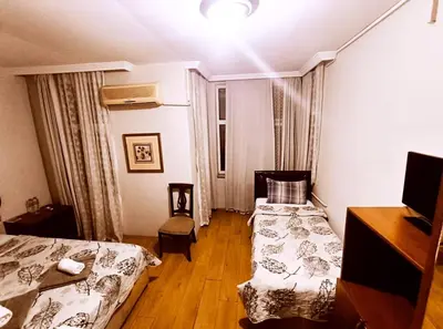 a hotel room with two beds and a table and a desk at Hotel Acar in Istanbul