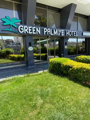 a green palms hotel sign in front of a building at Green Palmiye Hotel in Avcılar