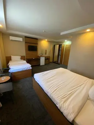 a hotel room with two beds and a television at Green Palmiye Hotel in Avcılar