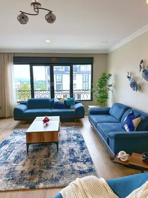 a living room with two blue couches and a table at Bamboo Grove 2 and 3 bedroom apartments - Izmit Kocaeli in Çavuşçiftliği