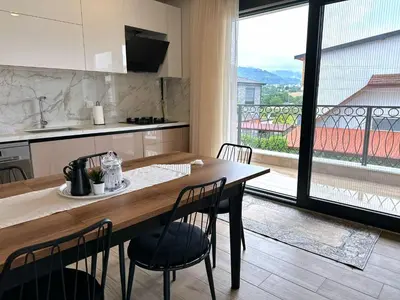 a kitchen with a table and chairs and a large window at Bamboo Grove 2 and 3 bedroom apartments - Izmit Kocaeli in Çavuşçiftliği