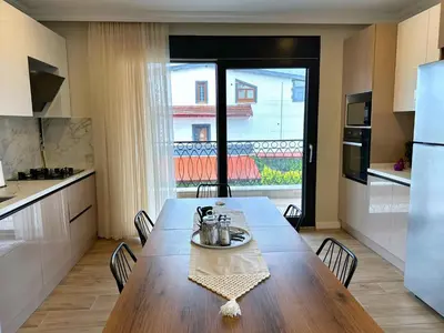 a kitchen with a wooden table and a large window at Bamboo Grove 2 and 3 bedroom apartments - Izmit Kocaeli in Çavuşçiftliği