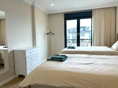 a bedroom with two beds and a dresser and a window at Bamboo Grove 2 and 3 bedroom apartments - Izmit Kocaeli in Çavuşçiftliği