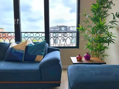 a living room with a blue couch and large windows at Bamboo Grove 2 and 3 bedroom apartments - Izmit Kocaeli in Çavuşçiftliği