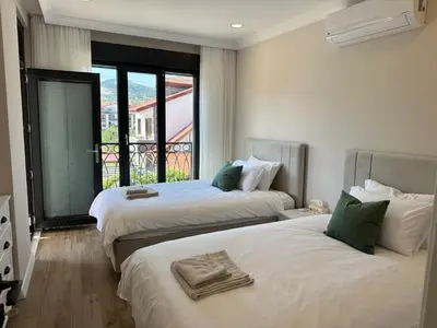 two beds in a room with a large window at Bamboo Grove 2 and 3 bedroom apartments - Izmit Kocaeli in Çavuşçiftliği