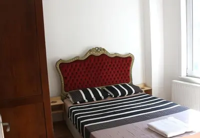 a bed with a red headboard in a room at Super Location Cosy Apartment TaximHome 3 at Taksim Cihangir in Istanbul