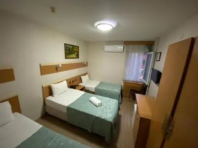 a hotel room with two beds and a desk at Hotel Oz Villa in Istanbul
